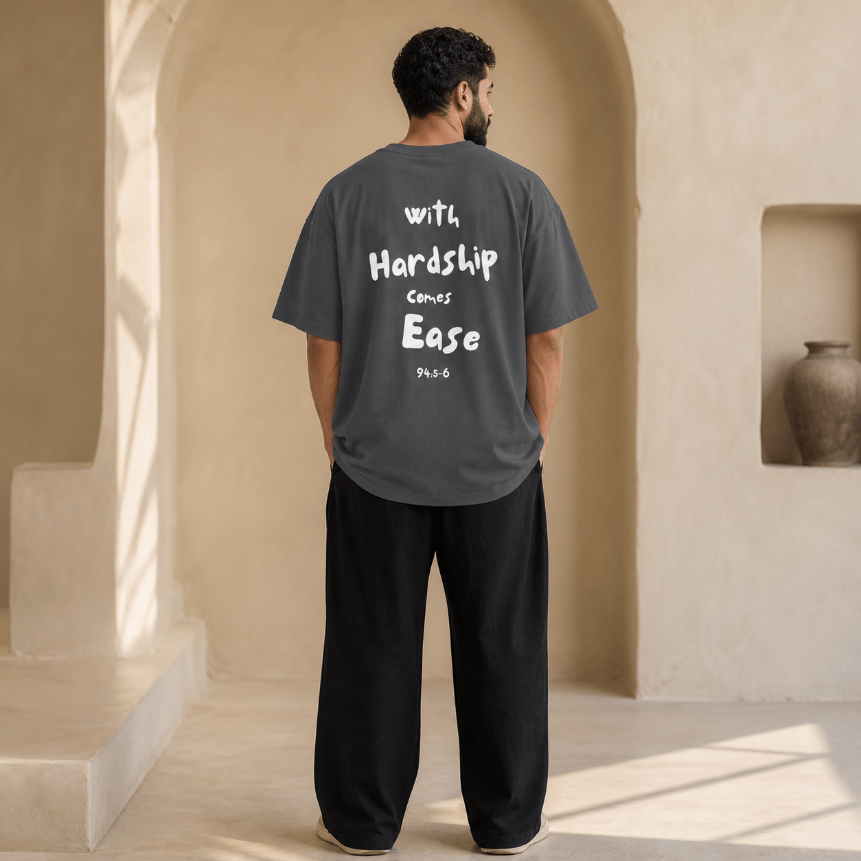 Man wearing the Hardship Comes Ease Grey T-shirt, back view - Ummah Collective
